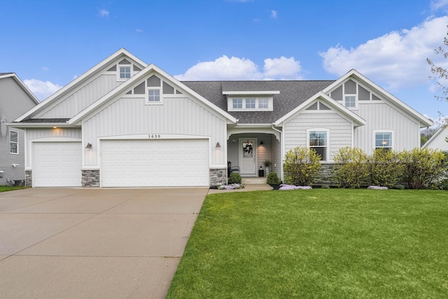 craftsman-style home with stone siding, board and batten siding, roof with shingles, a front lawn, and an attached garage