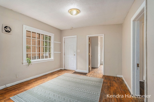 747 Alpine Ave NW, Grand Rapids, MI 49504 - hallway featuring baseboards, wood finished floors, and a textured ceiling