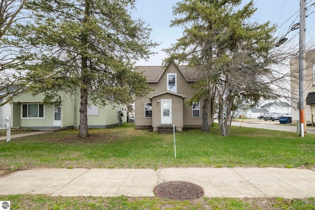 110 W 4th St, Kalkaska, MI 49646 - bungalow-style home featuring a front lawn, a shingled roof, and entry steps