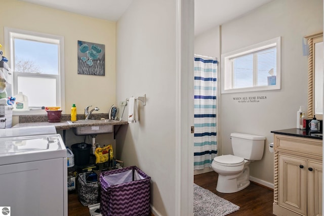 110 W 4th St, Kalkaska, MI 49646 - full bathroom featuring separate washer and dryer, healthy amount of natural light, wood finished floors, and a sink