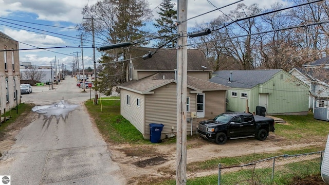 110 W 4th St, Kalkaska, MI 49646 - view of side of property with a shingled roof, fence, and central AC