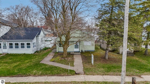 110 W 4th St, Kalkaska, MI 49646 - view of front of house featuring a front lawn and roof with shingles