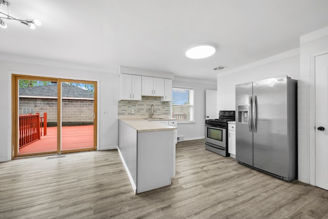 839 E Hayes Ave, Hazel Park, MI 48030 - kitchen with stainless steel appliances, a sink, a peninsula, light countertops, and backsplash