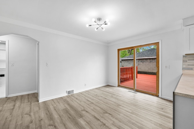 839 E Hayes Ave, Hazel Park, MI 48030 - unfurnished dining area with light wood-type flooring, a chandelier, baseboards, and arched walkways