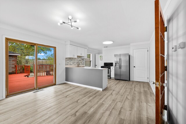 839 E Hayes Ave, Hazel Park, MI 48030 - kitchen featuring appliances with stainless steel finishes, a peninsula, healthy amount of natural light, a sink, and ornamental molding