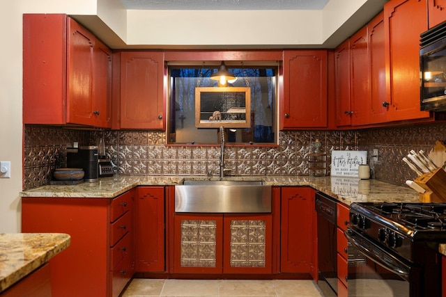kitchen featuring a sink, black appliances, light stone counters, and tasteful backsplash