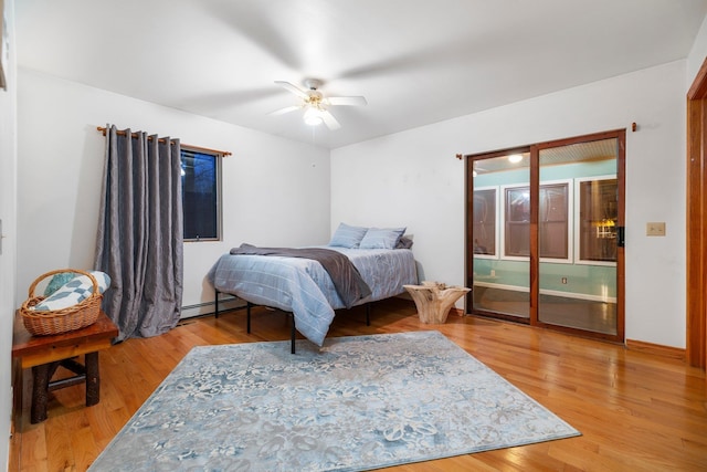 bedroom featuring baseboard heating, light wood-style flooring, and ceiling fan