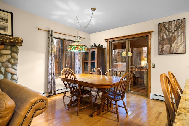 dining area featuring light wood-style flooring, a baseboard radiator, and french doors