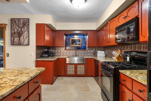 kitchen with black appliances, a sink, decorative backsplash, and light stone counters
