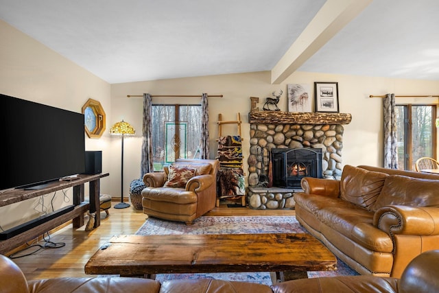 living area with a stone fireplace and hardwood / wood-style flooring