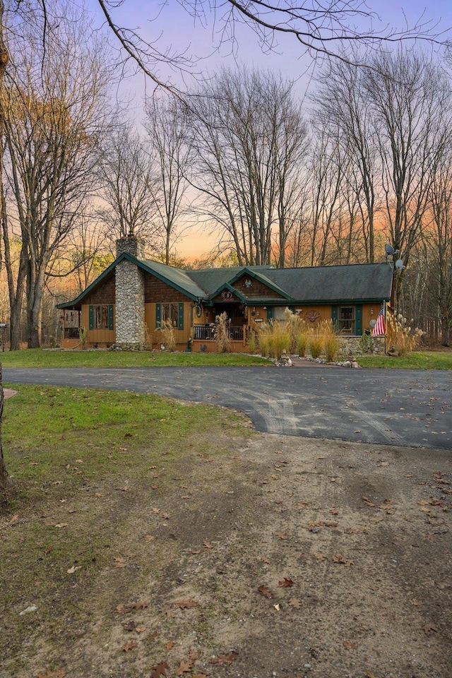 mid-century inspired home featuring a chimney and driveway