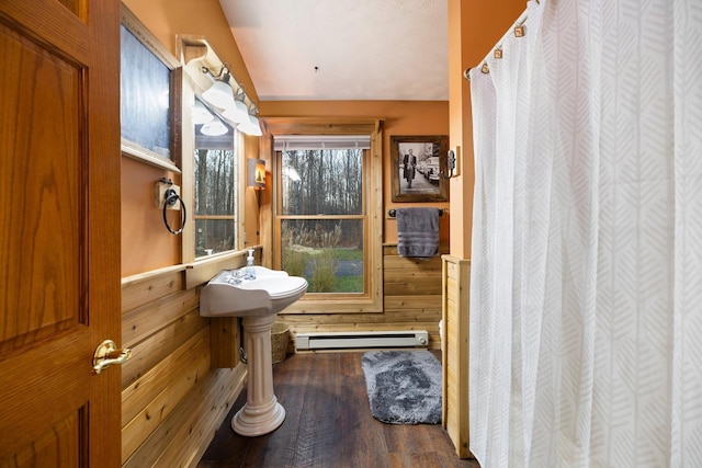 bathroom featuring a baseboard radiator, wood finished floors, wood walls, and curtained shower