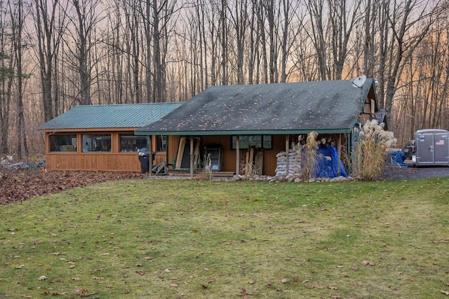 ranch-style house featuring a front yard, a porch, and metal roof