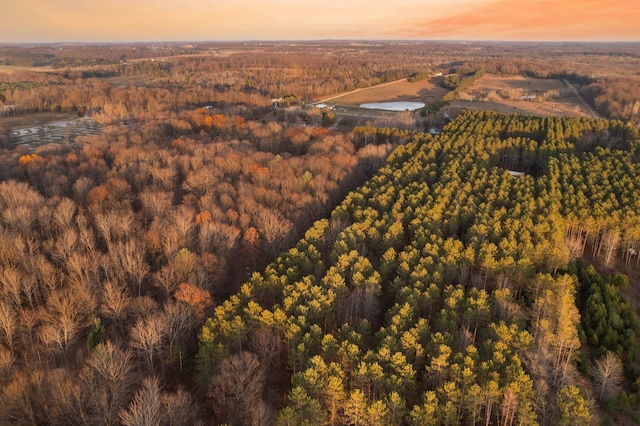 aerial view of property and surrounding area with a heavily wooded area