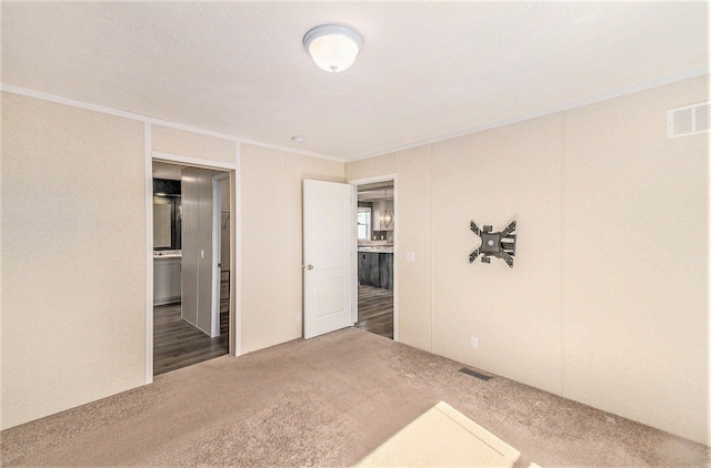 13780 Alaska Ave, Eagle, MI 48822 - unfurnished bedroom with crown molding, carpet flooring, and ensuite bathroom