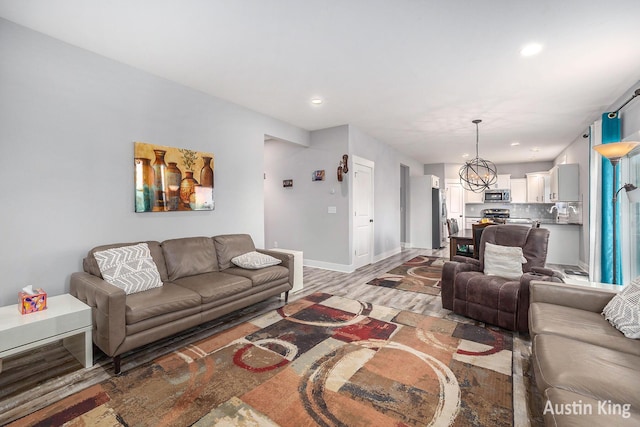 6526 Alward Dr, Hudsonville, MI 49426 - living room featuring light wood-type flooring, baseboards, recessed lighting, and a chandelier