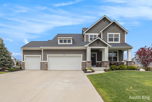 6526 Alward Dr, Hudsonville, MI 49426 - craftsman house with stone siding, concrete driveway, a porch, an attached garage, and roof with shingles