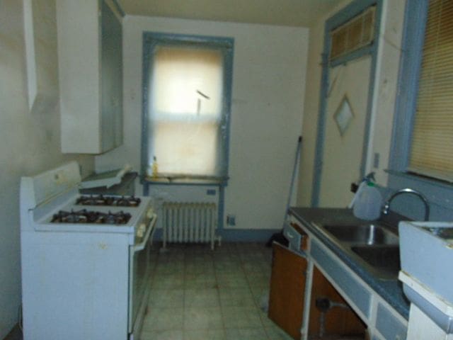 50 Glendale St, Highland Park, MI 48203 - kitchen featuring white gas range oven, radiator, and a sink