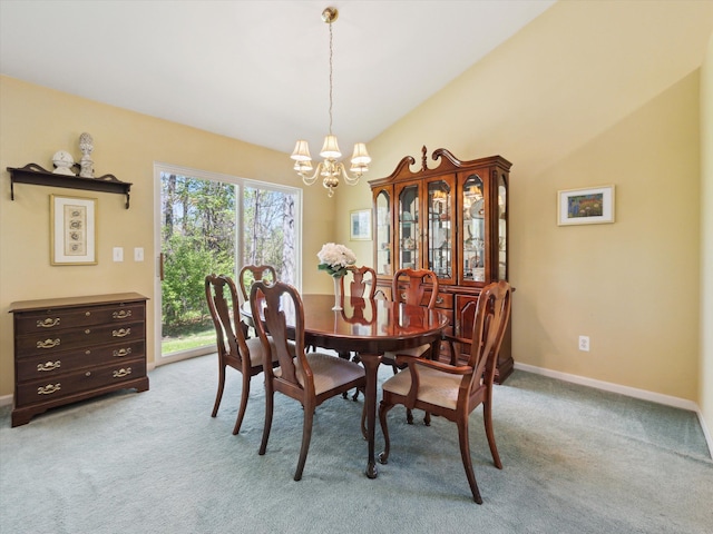 dining room featuring a chandelier, light colored carpet, lofted ceiling, and baseboards