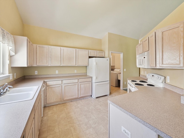 kitchen with white appliances, light brown cabinetry, a sink, vaulted ceiling, and washer / dryer