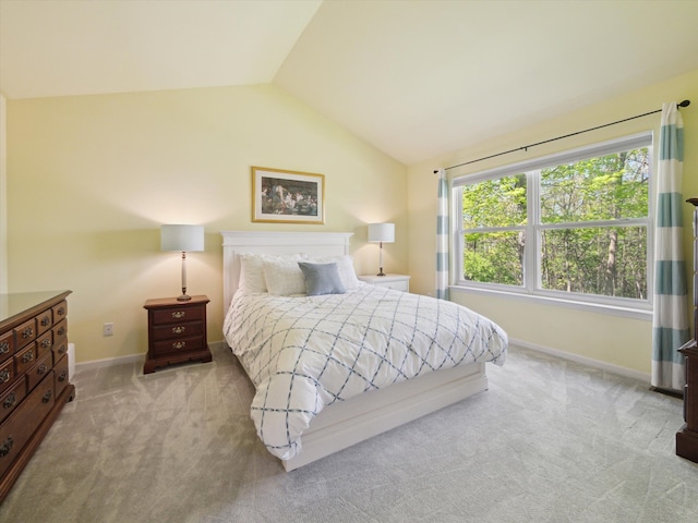 carpeted bedroom featuring lofted ceiling and baseboards
