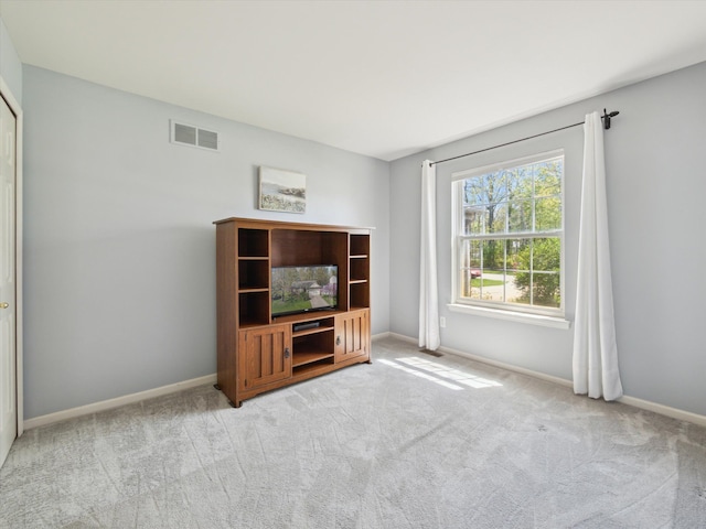 unfurnished living room featuring carpet flooring and baseboards