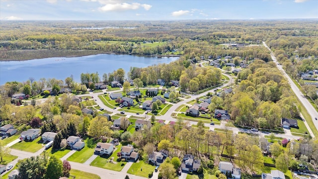 aerial overview of property's location featuring a large body of water, a forest, and nearby suburban area