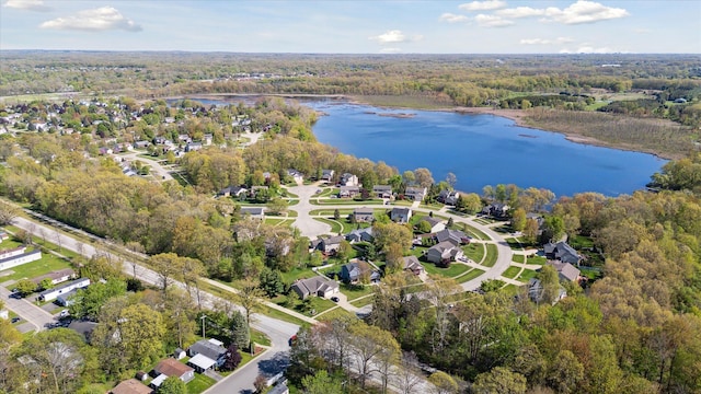 aerial view of property's location featuring a nearby body of water and a forest