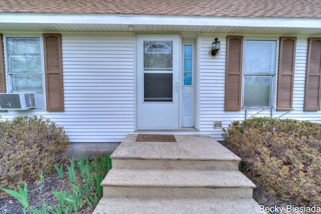 823 Warner St, Whitehall, MI 49461 - view of exterior entry featuring cooling unit and a shingled roof
