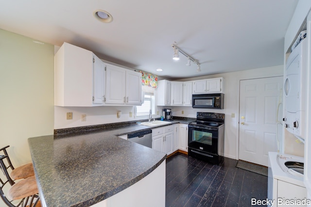 823 Warner St, Whitehall, MI 49461 - kitchen with black appliances, stacked washer / drying machine, dark countertops, a peninsula, and a sink