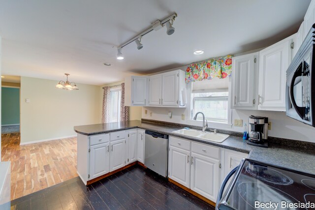823 Warner St, Whitehall, MI 49461 - kitchen with black appliances, a sink, a peninsula, dark countertops, and recessed lighting