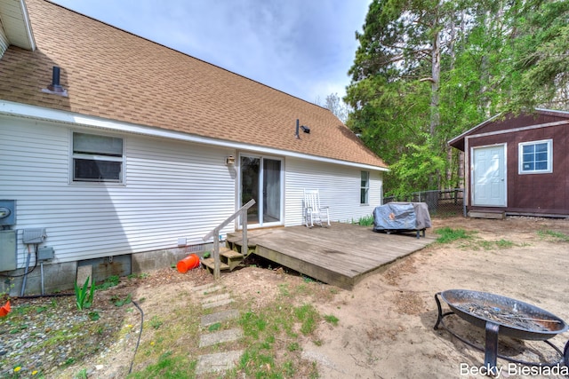 823 Warner St, Whitehall, MI 49461 - back of property featuring a fire pit, fence, a deck, and roof with shingles