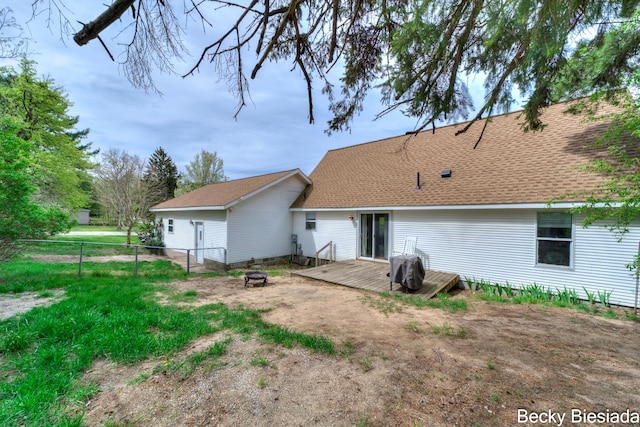 823 Warner St, Whitehall, MI 49461 - back of house featuring fence, an outdoor fire pit, a wooden deck, and roof with shingles