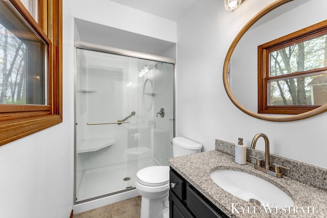 full bath with toilet, a stall shower, vanity, and tile patterned flooring