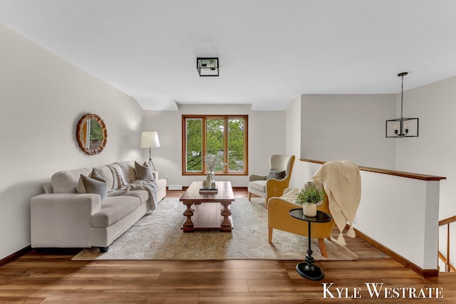 living room featuring wood finished floors, baseboards, and a chandelier