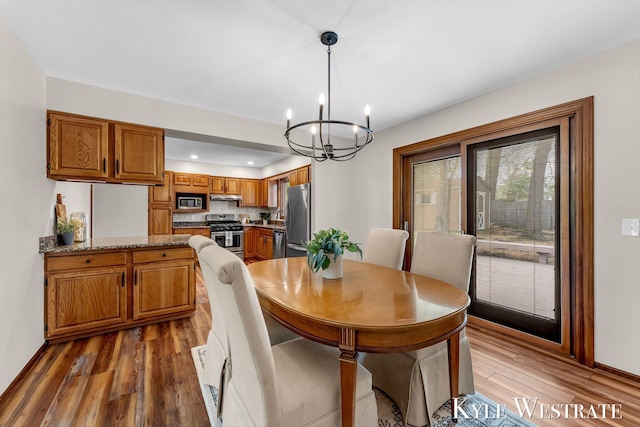 dining space with a chandelier, wood finished floors, and recessed lighting