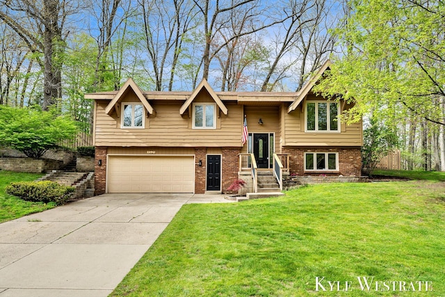 split foyer home featuring an attached garage, brick siding, a front lawn, and concrete driveway