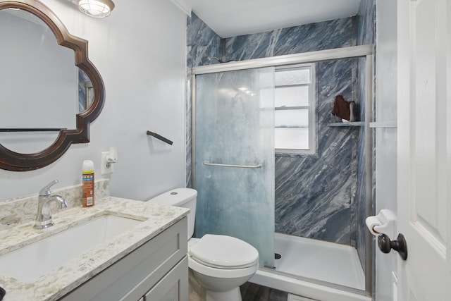 bathroom with a marble finish shower, toilet, and vanity