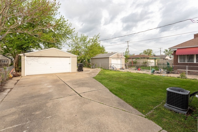 view of yard with a detached garage, an outbuilding, and central air condition unit