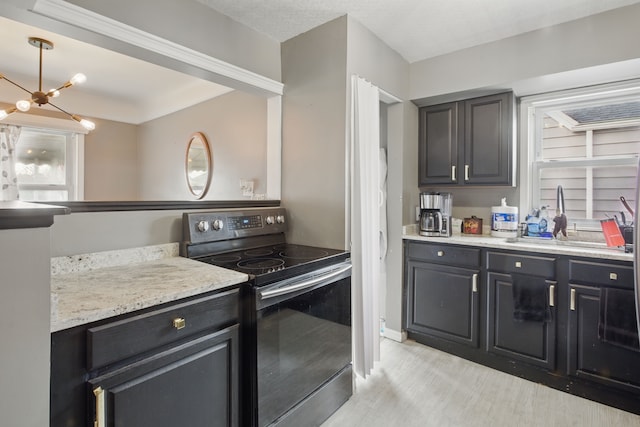 kitchen with electric stove, a chandelier, and dark cabinets