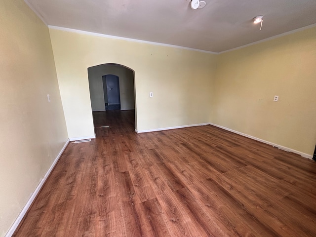 17233 Fenelon St, Hamtramck, MI 48212 - spare room featuring arched walkways, ornamental molding, dark wood-style flooring, and baseboards