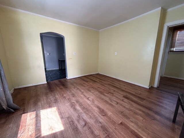 17233 Fenelon St, Hamtramck, MI 48212 - empty room featuring arched walkways, ornamental molding, wood finished floors, and baseboards