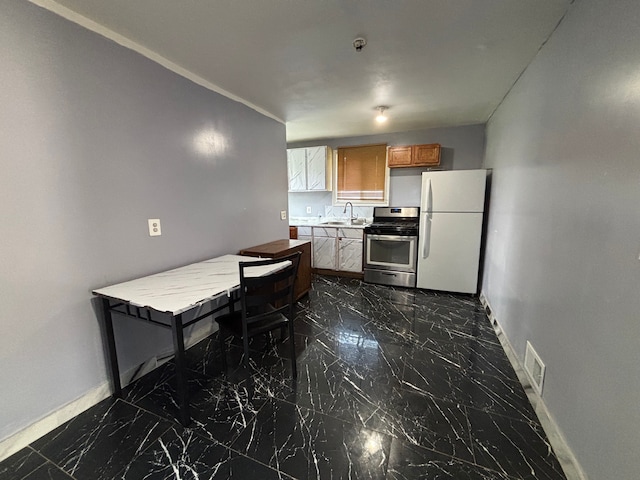 17233 Fenelon St, Hamtramck, MI 48212 - kitchen featuring freestanding refrigerator, gas stove, dark marble finish floors, a sink, and baseboards
