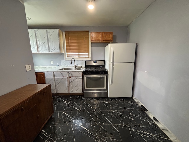 17233 Fenelon St, Hamtramck, MI 48212 - kitchen with freestanding refrigerator, stainless steel range with gas cooktop, a sink, and dark marble finish floors
