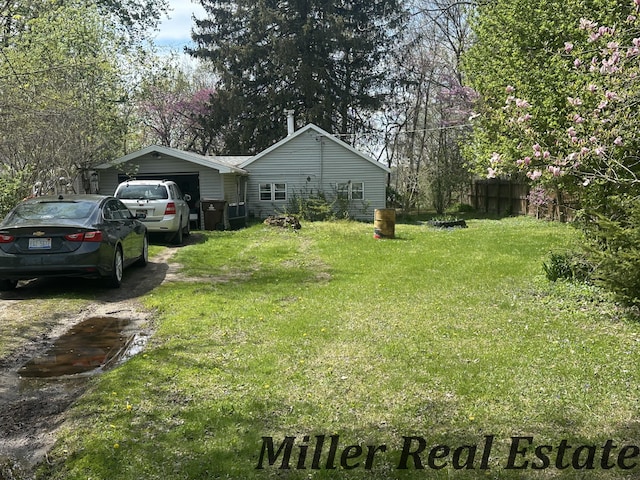 7755 Woodland Rd, Lake Odessa, MI 48849 - view of yard featuring an attached garage and dirt driveway