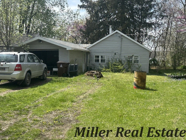 7755 Woodland Rd, Lake Odessa, MI 48849 - rear view of house featuring a lawn and an attached garage
