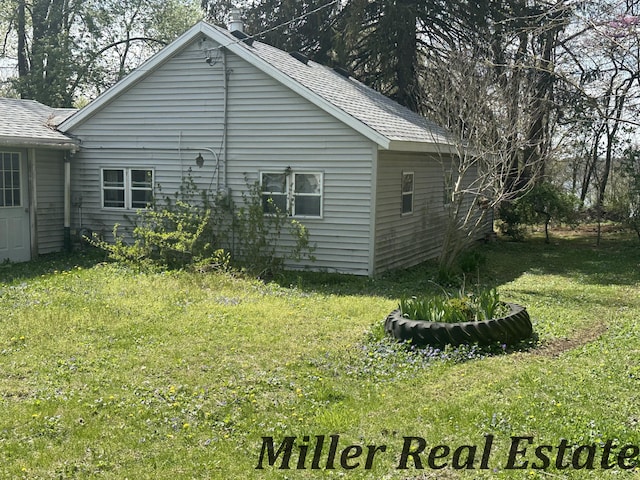 7755 Woodland Rd, Lake Odessa, MI 48849 - back of property featuring a shingled roof and a lawn