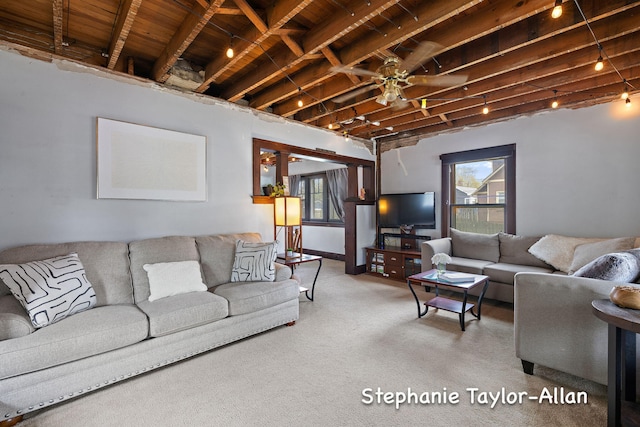 carpeted living area featuring healthy amount of natural light, beamed ceiling, ceiling fan, and wood ceiling