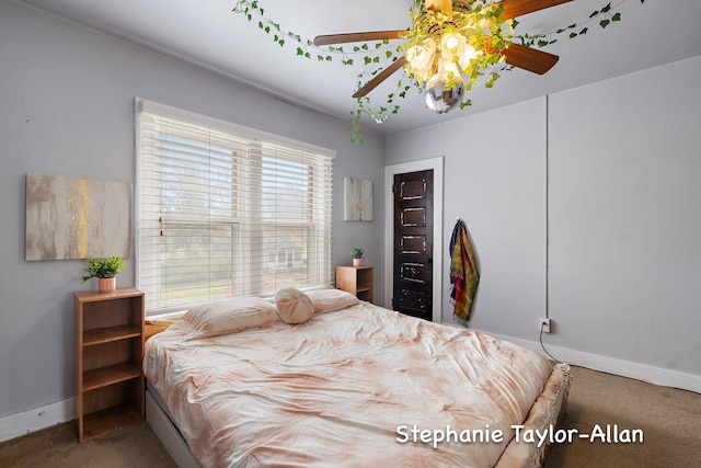 carpeted bedroom featuring baseboards and a ceiling fan