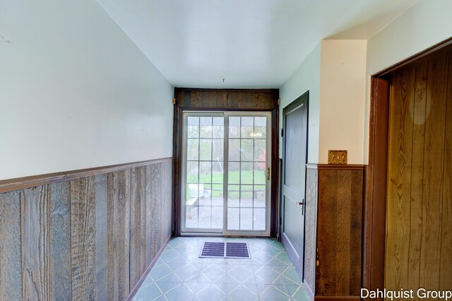 doorway featuring a wainscoted wall and tile patterned floors